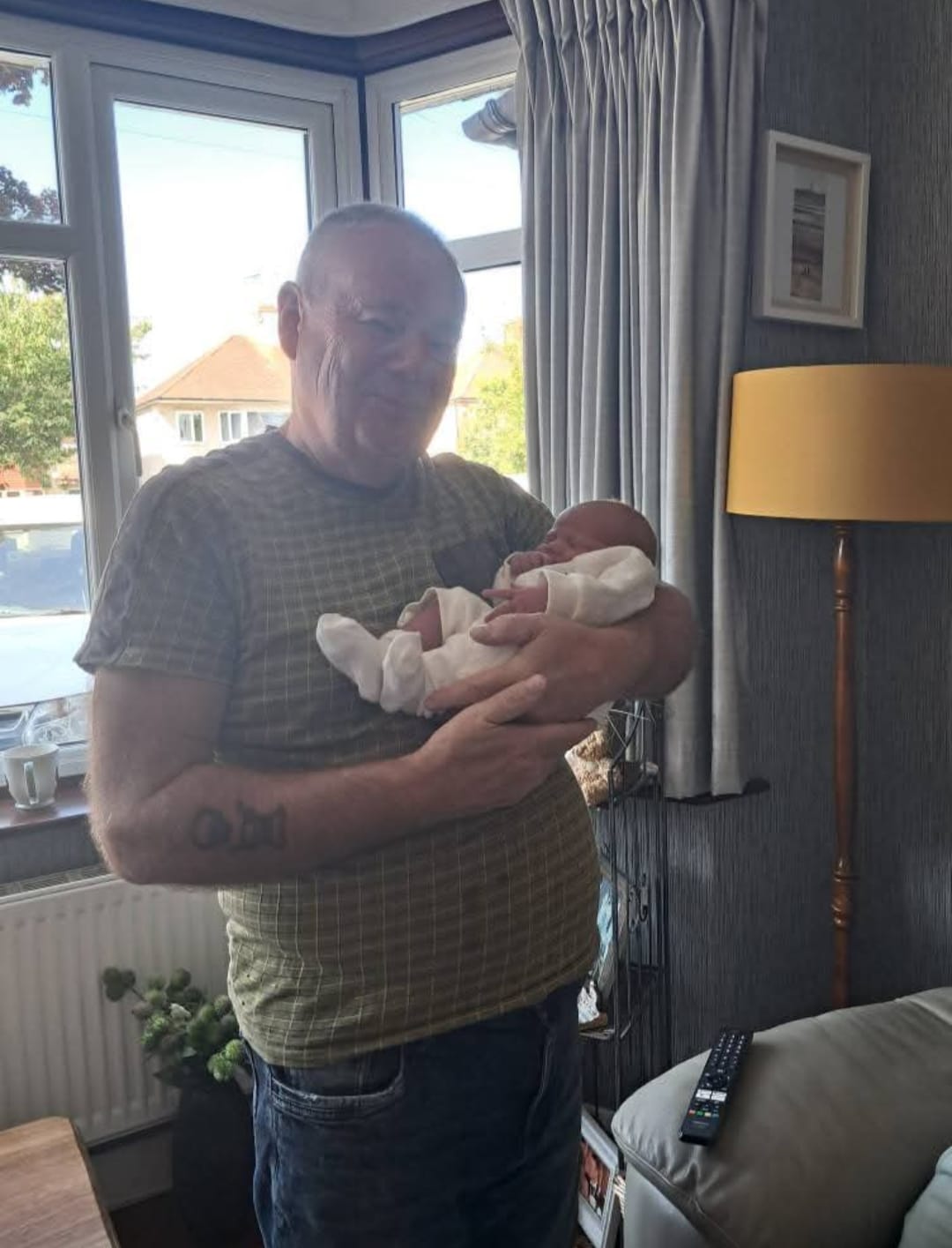 A grandfather meeting his newborn grandchild for the first time