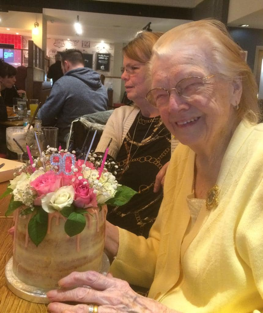 A celebration of ninety years — candles on a floral birthday cake